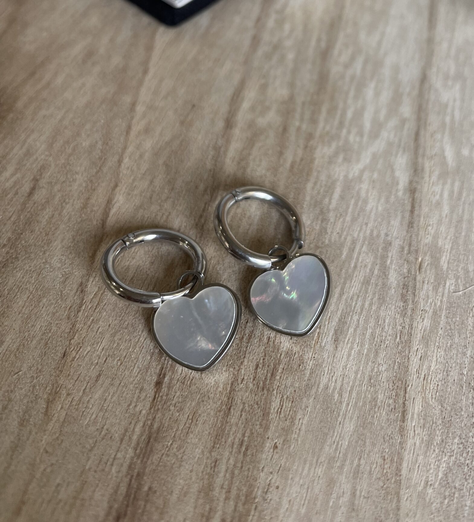 Boucles d&rsquo;oreilles créoles argentées avec pendentifs cœur nacré